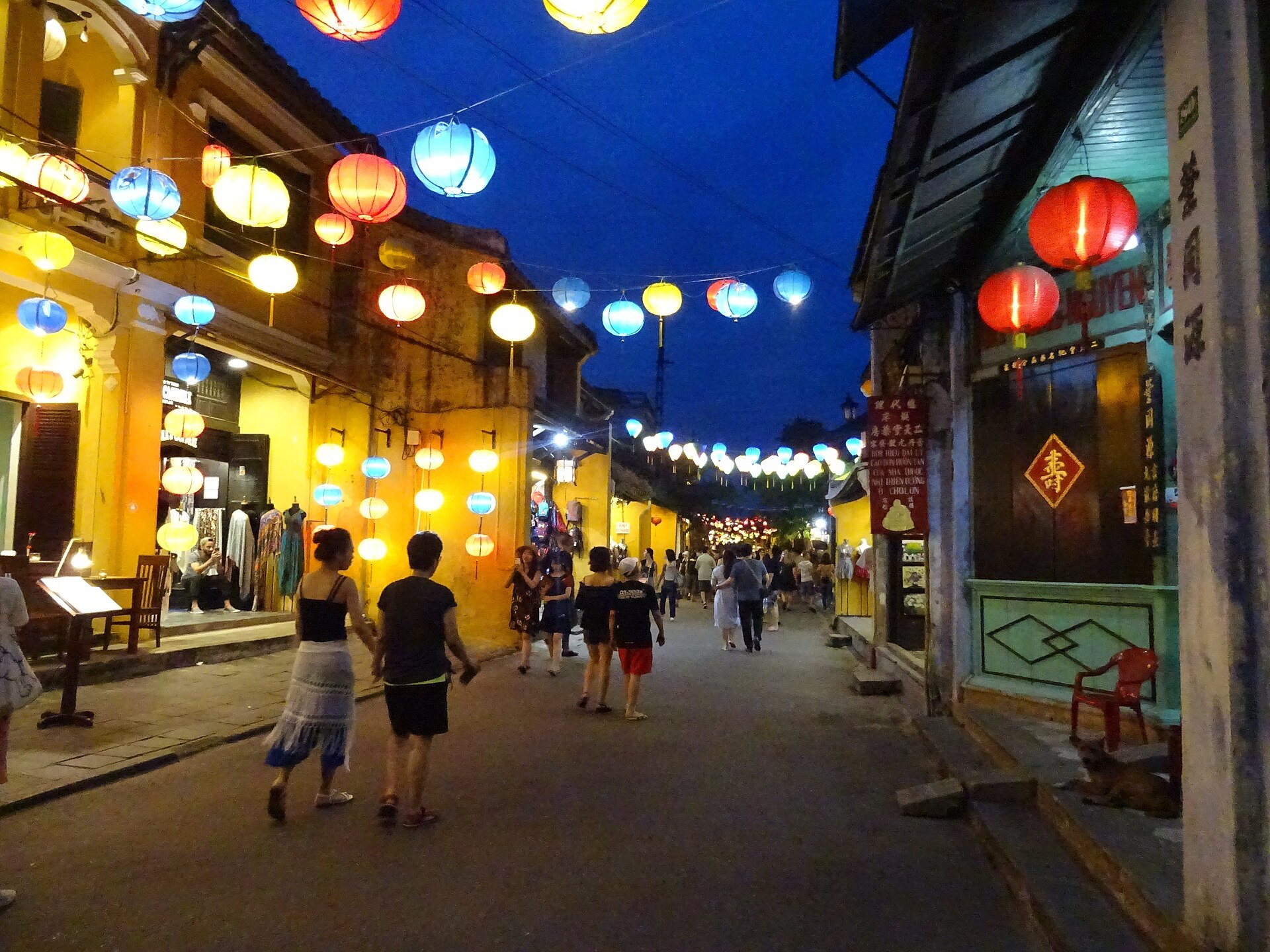 Coloured silk lanterns lit over a street in Hoi An old town at dusk