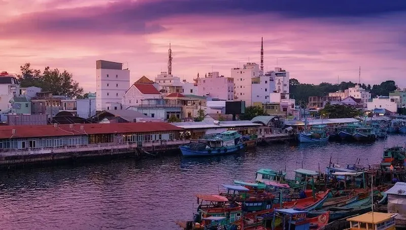 Ancient Ham Ninh fishing village Phu Quoc pink sunset with colorful traditional fishing boats wooden houses waterfront heritage architecture