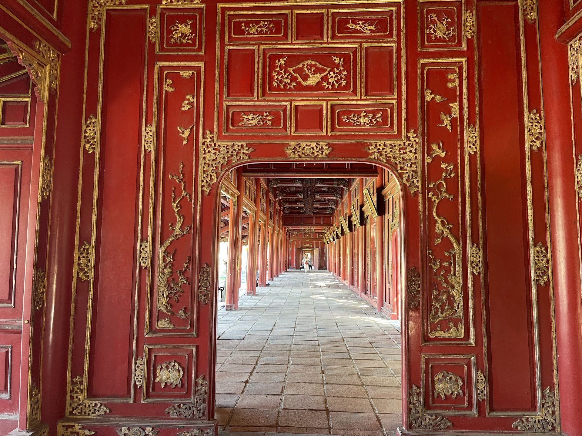 Red and gold doorways along a covered corridor in Hue Imperial City