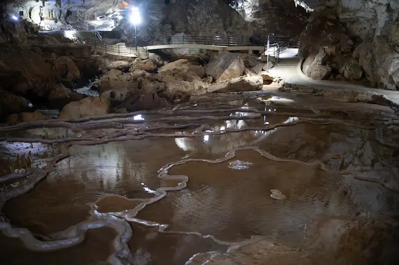 מטיילים באמבט בוץ במערה האפלה בפונג נה