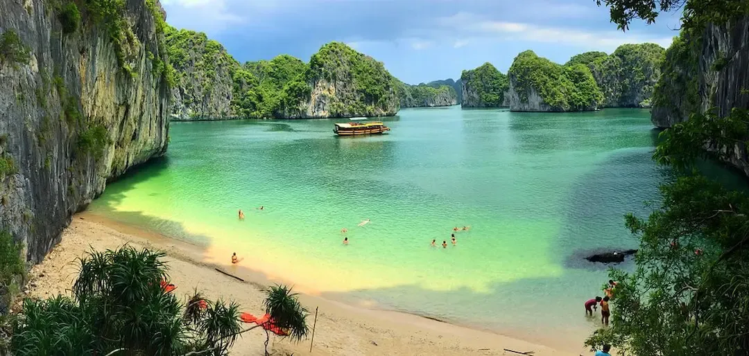 Secluded Beach on Lan Ha Bay Near Cat Ba Island With Turquoise Water Limestone Cliffs and Swimmers