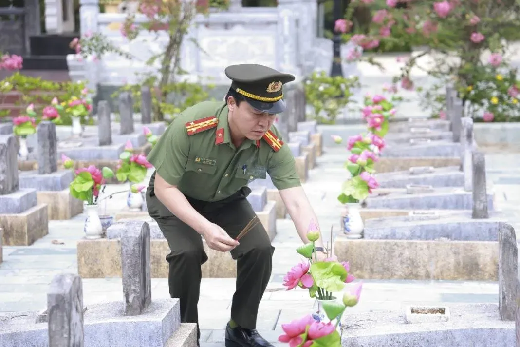 Chiến sĩ công an thắp hương tại nghĩa trang