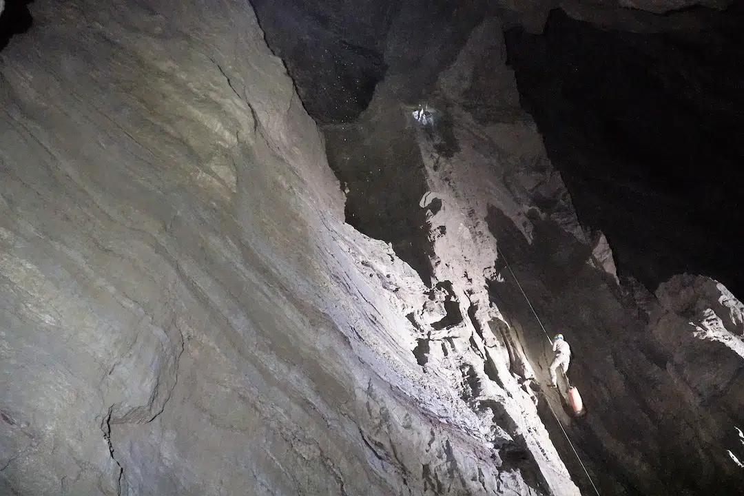 חוקר בודד גולש על חבל בפיר אנכי ענק במערת ורייובקינה
