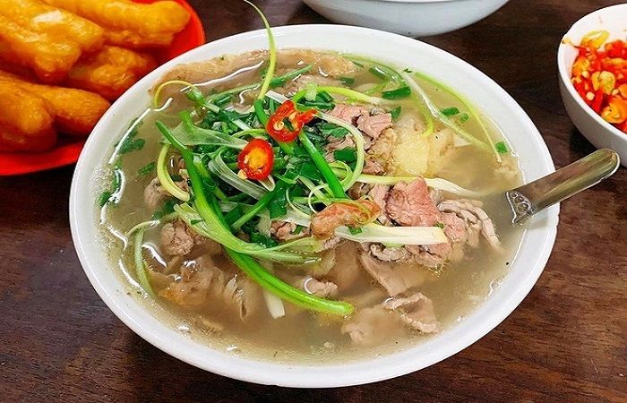 Bowl of Vietnamese Pho With Beef, Fresh Herbs, and Chili Peppers