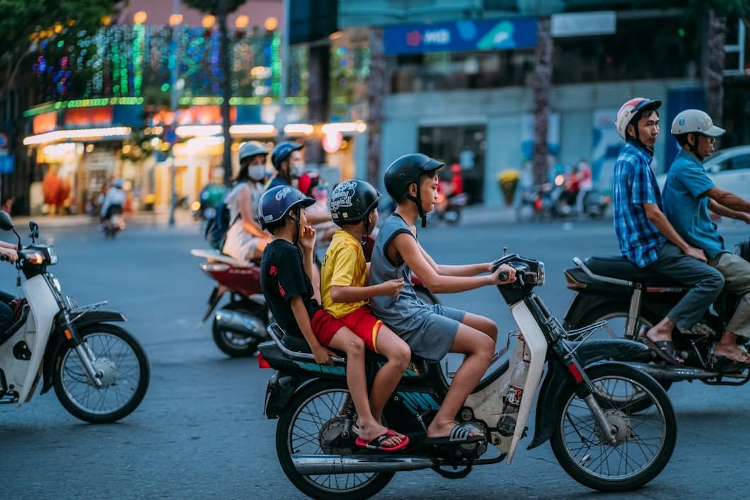 People Riding Scooters on Busy Hanoi Street in Vietnam